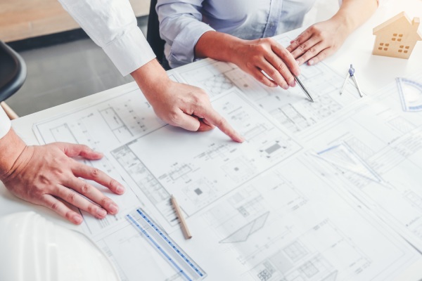 Man hands showing house blueprint
