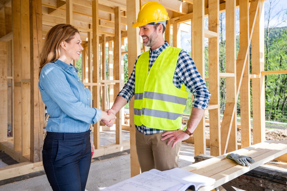 Engineer or architect on construction site of new house reach agreement with investor and home owner giving handshake