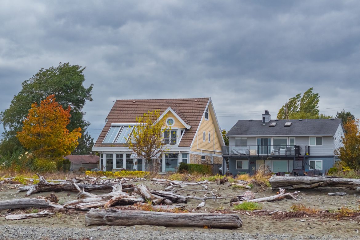 Houses on the beach during Stormy Weather. Coast houses beachfront waterfront in overcast day in Brirish Columbia West Coast Canada. Nobody, street photo, selective focus