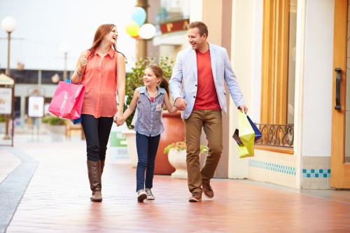 Family Walking Through Mall With Shopping Bags